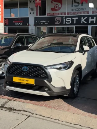 White Toyota Corolla Cross in front of the showroom